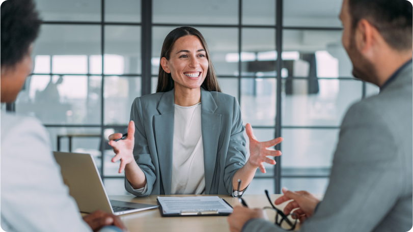 Three people in a conference room talking