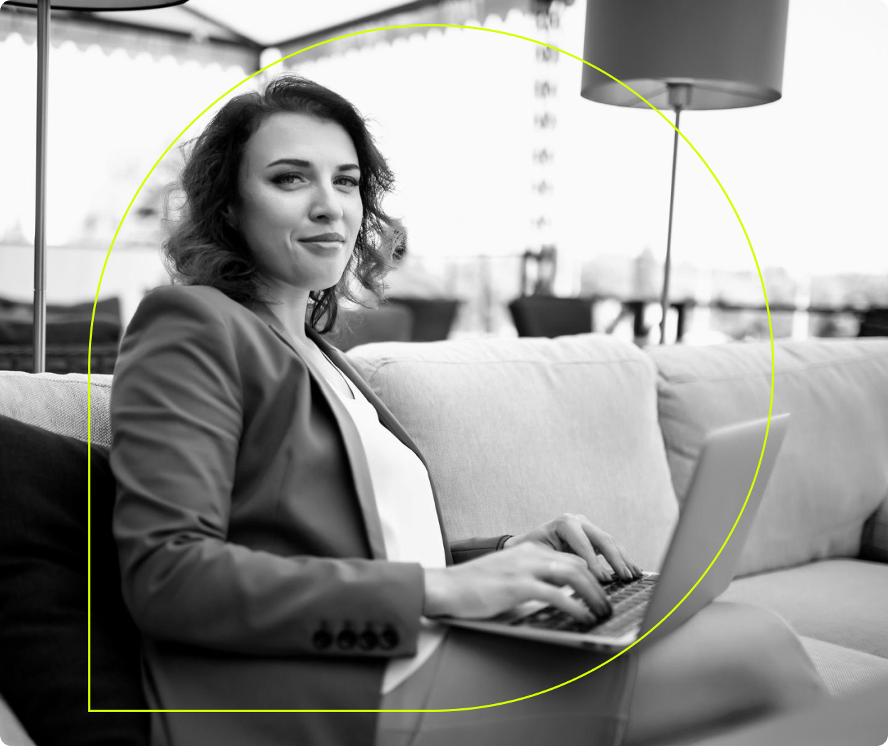 Person sitting on a couch with a laptop on their lap.